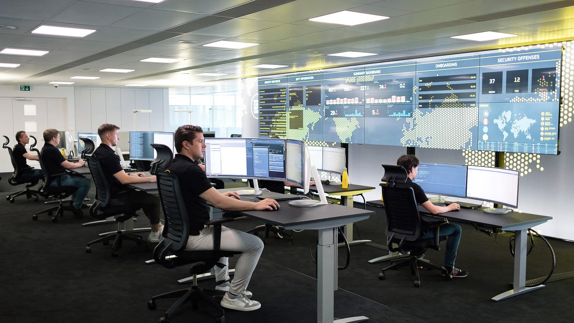 Centre de sécurité informatique avec des collaborateurs travaillant sur des postes équipés d'écrans, associé à l'écosystème d'apprentissage Infoguard